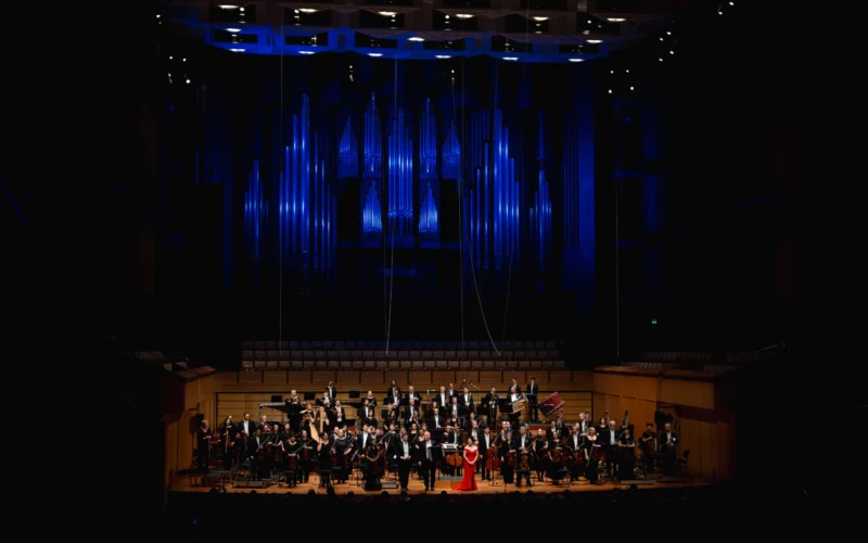 The full Queensland Symphony Orchestra standing on the QPAC Concert Hall stage, accepting a passionate standing ovation and rapturous applause from the audience at the conclusion of the Italian Gala.